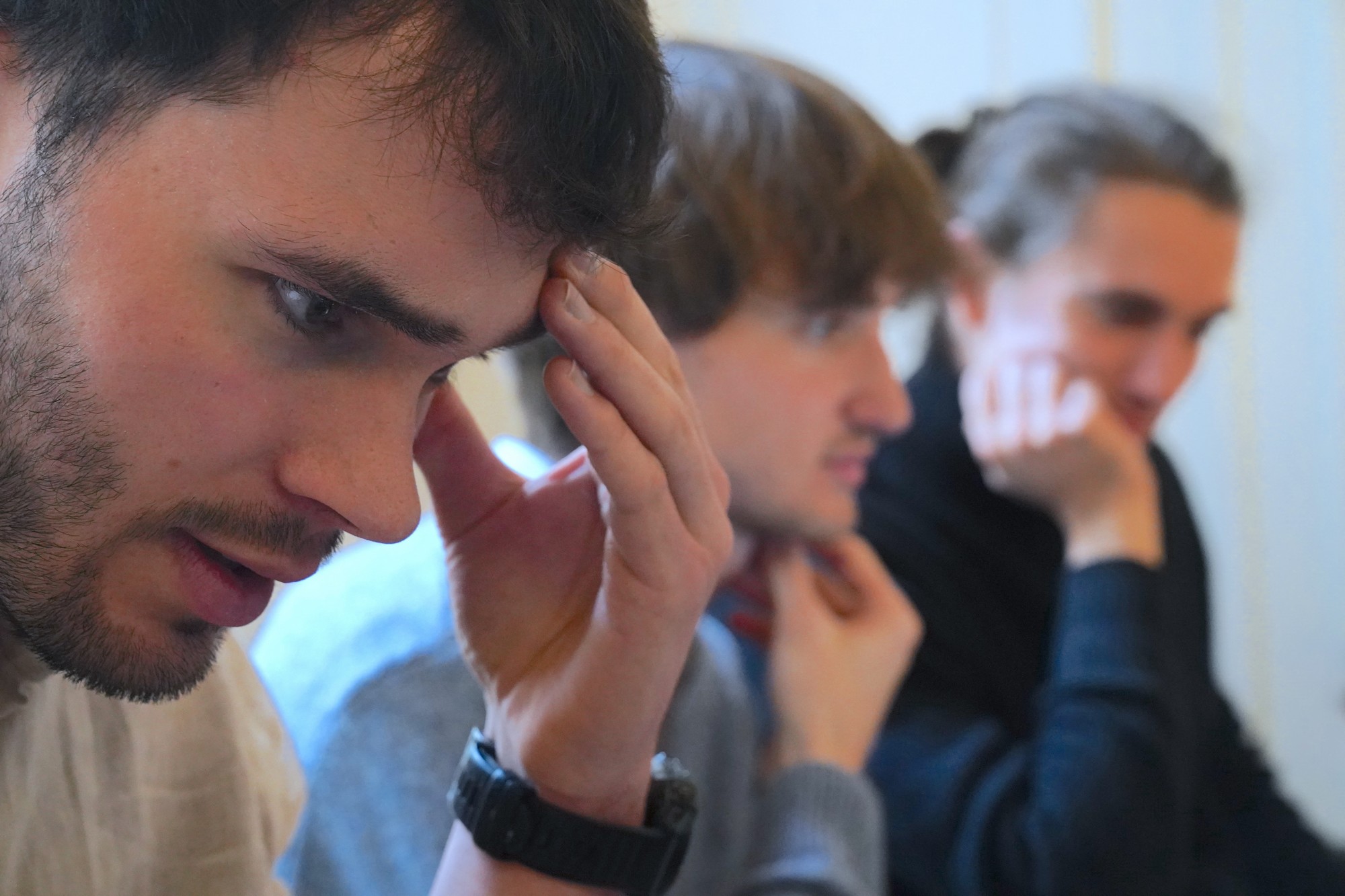 Participant pensif, la main sur le front, pendant une session de formation