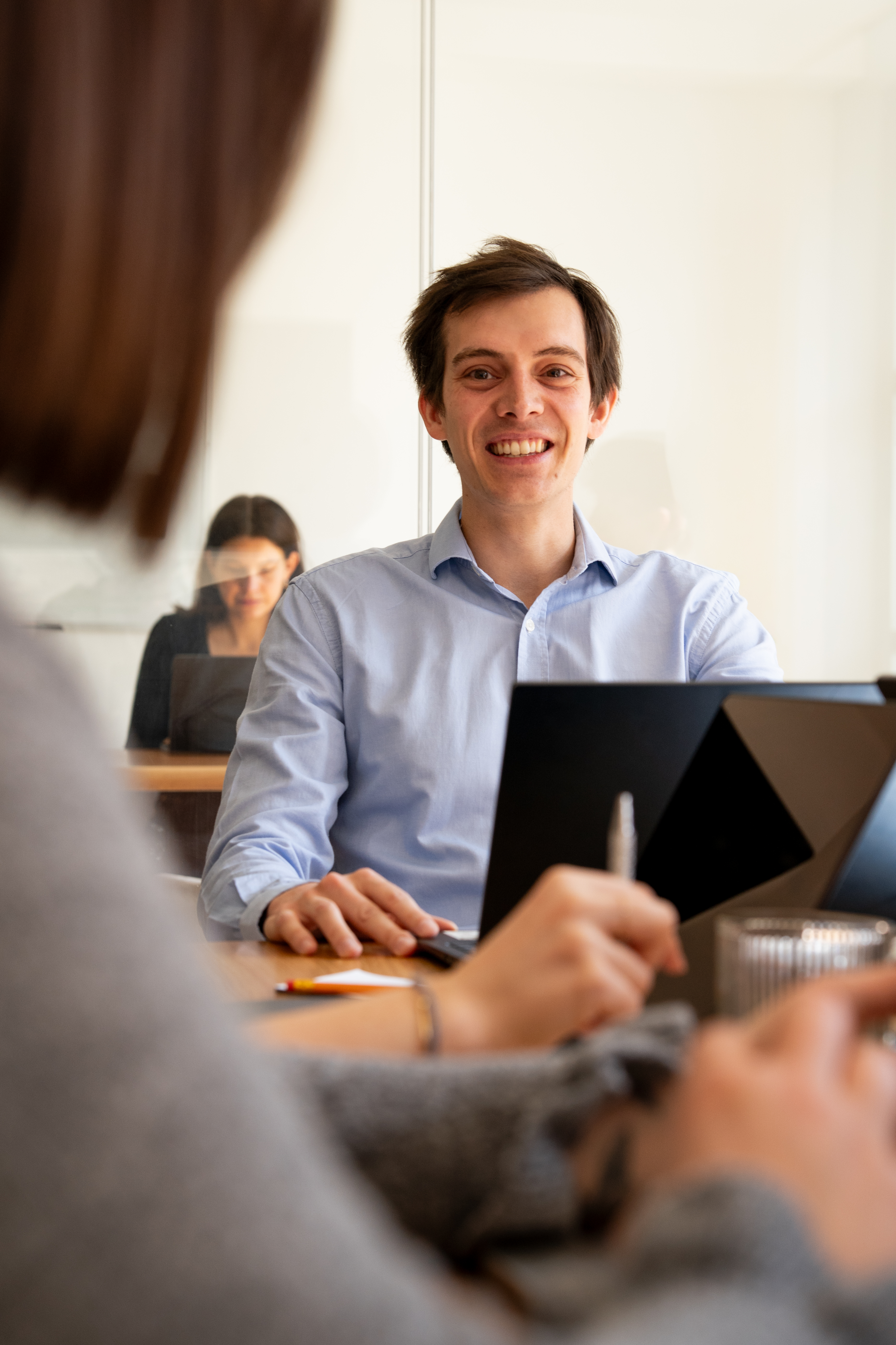 A Galadrim team in a workshop around a meeting table, laptops open