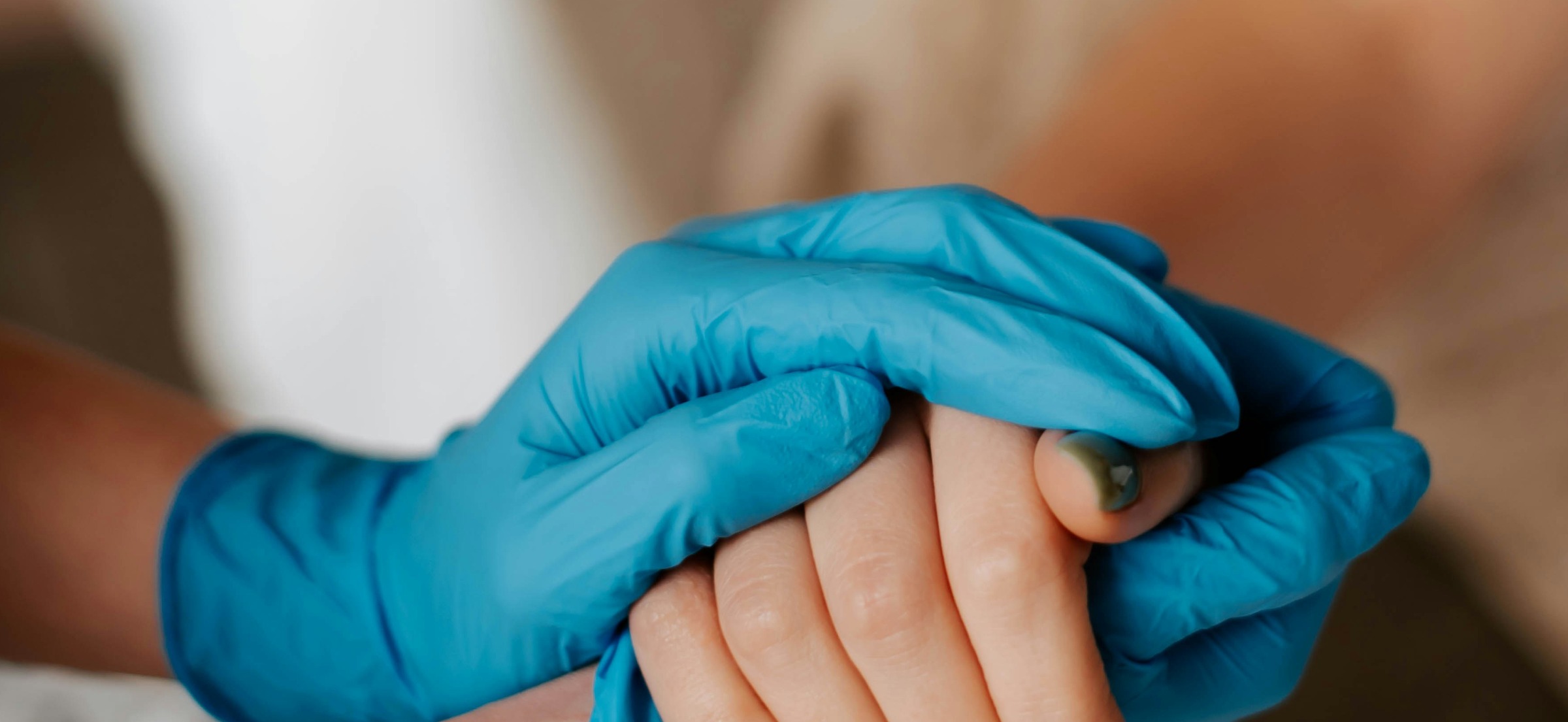 Main gantée d'un professionnel de santé tenant la main d'un patient