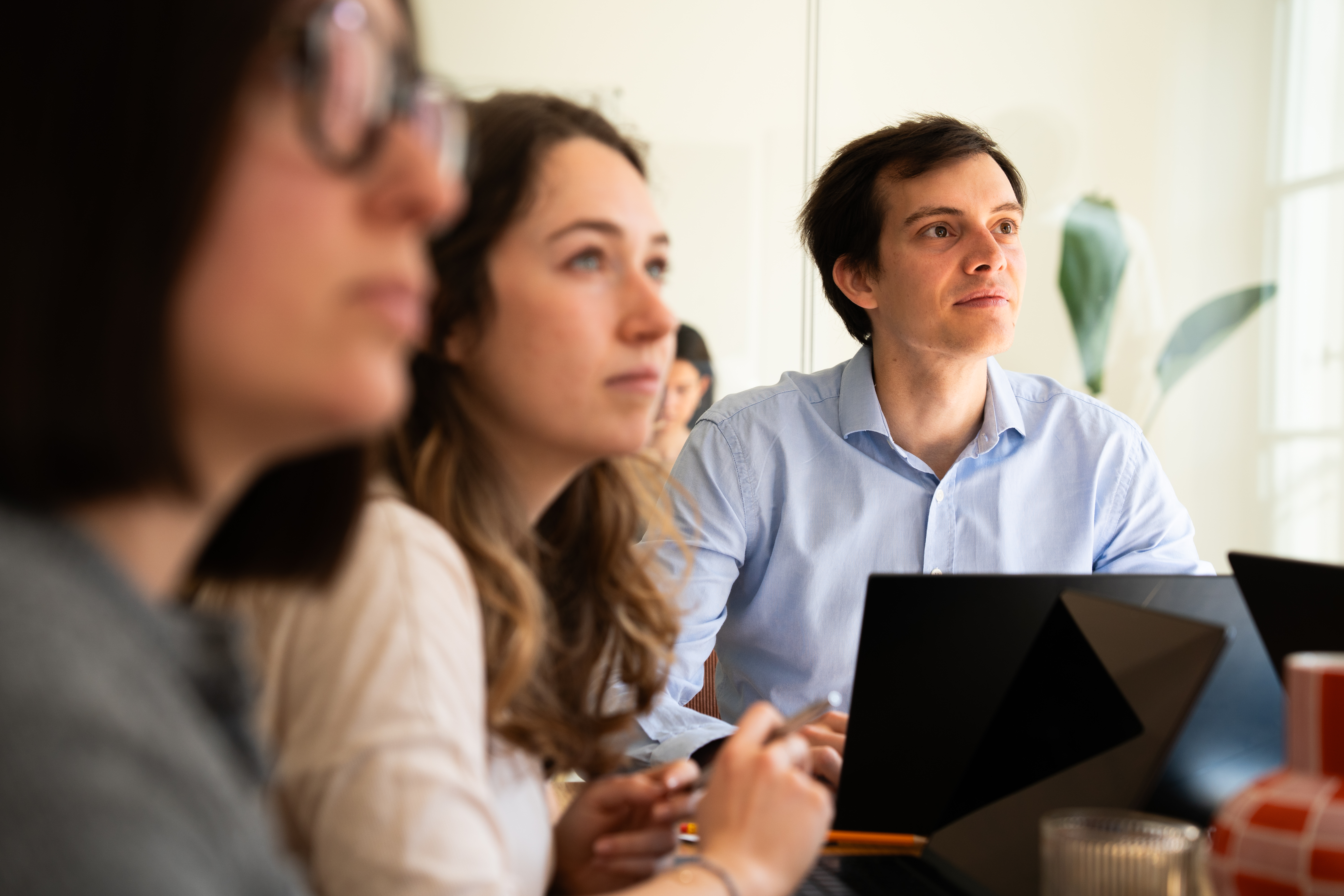 Une équipe attentive autour d'une table avec des ordinateurs portables