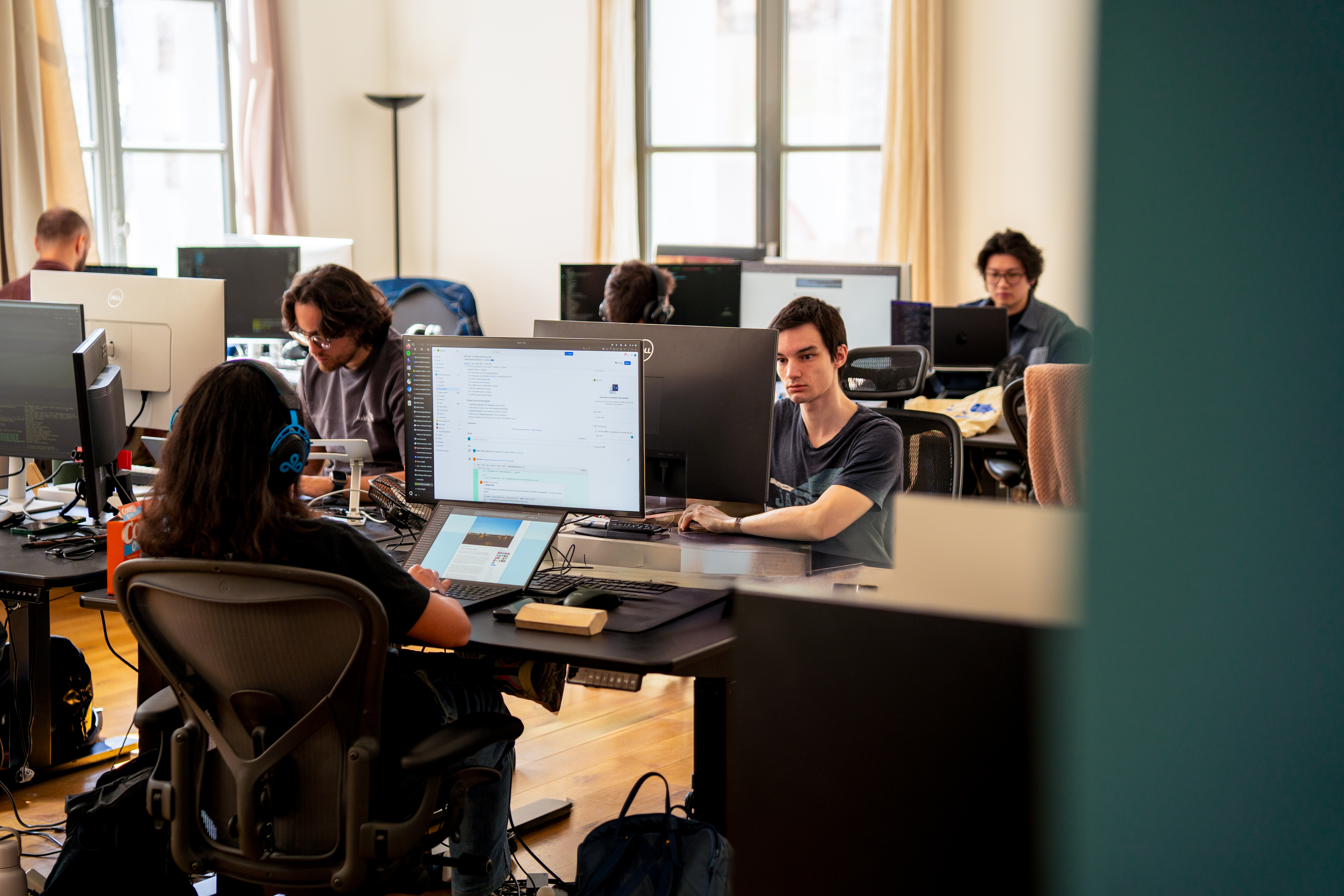 Plusieurs personnes travaillent sur leurs ordinateurs dans un bureau en open space